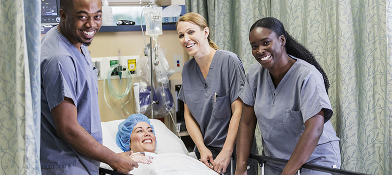 Patiente entourée de 3 soignants souriants - La Prévention Médicale